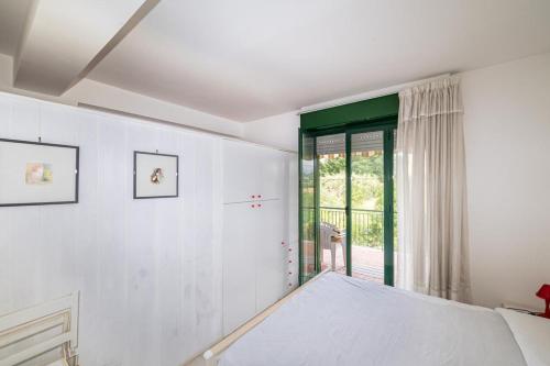 Habitación blanca con cama y ventana en Casa Jaya Taormina en Schisò