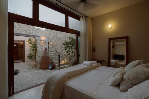 a bedroom with a bed and a large window at Hermosa casa junto a la muralla in Campeche