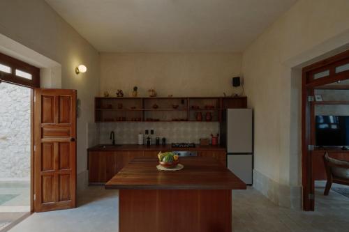 a kitchen with a counter and a refrigerator at Hermosa casa junto a la muralla in Campeche