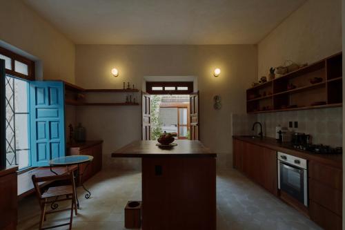 a kitchen with wooden cabinets and a blue door at Hermosa casa junto a la muralla in Campeche