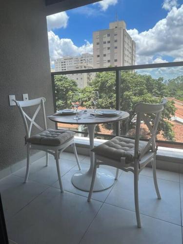 d'une table et de chaises sur un balcon avec vue. dans l'établissement Studio Moderno em Pinheiros - 300m do Metrô e HC, à São Paulo
