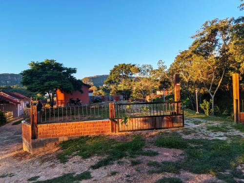 a fence in front of a yard with trees at Pouso de Santana in Tiradentes