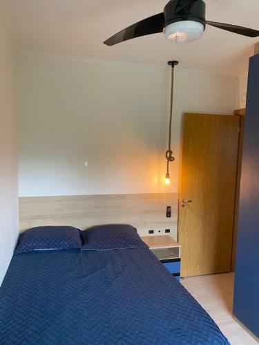 um quarto com uma cama azul e uma porta de madeira em APTO PRIME 2 DORM COM GARAGEM À 2,9km DA FENAC em Novo Hamburgo