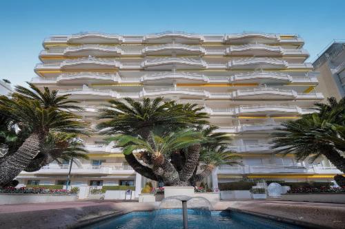 un grand bâtiment avec des palmiers devant dans l'établissement Le Ed- Croisette - Parking - VCA, à Cannes