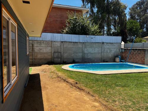a swimming pool in a yard next to a house at Alojamiento Rustico Belloto 1 in Quilpué