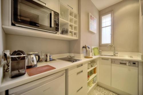 une cuisine avec un évier et un micro-ondes dans l'établissement Le Ed- Croisette - Parking - VCA, à Cannes