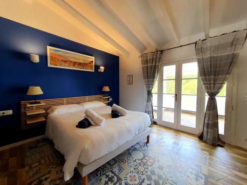 1 dormitorio con 1 cama grande y pared azul en Galdana's House en Cala Galdana