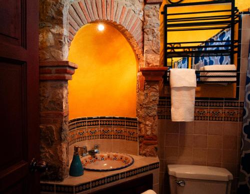 baño con lavabo y pared amarilla en Palacio del conquistador, en San Cristóbal El Bajo