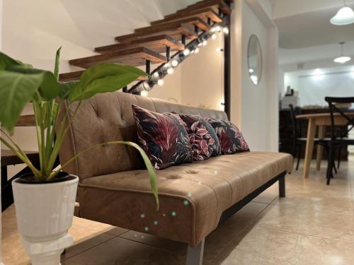 a couch with pillows and a plant in a room at Mar y Rio Duplex in Playa Unión