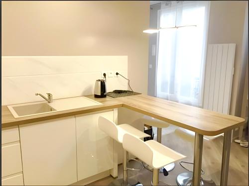 een keuken met een houten tafel en een wastafel bij Appartement moderne au centre de Paris, 3ème in Parijs