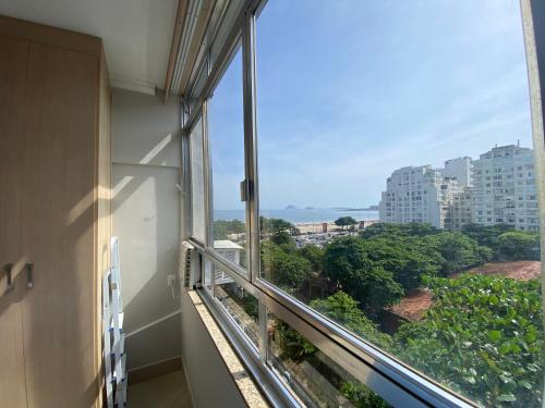 a room with a window with a view of a city at Loft Praia de Copacabana in Rio de Janeiro