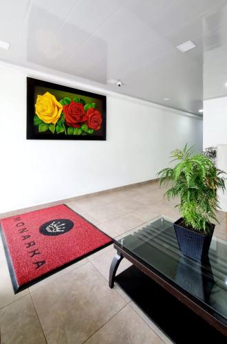 a room with a table and a flower painting on the wall at Hotel Monarka-Edificio in Popayan