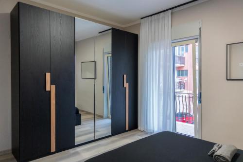 um quarto com um armário preto e uma porta de vidro em Casa Maria em Milazzo