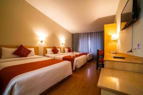 a hotel room with two beds and a television at Lake Titicaca Hotel in Puno