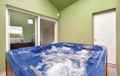 une baignoire bleue remplie d'eau dans une pièce dans l'établissement Holiday villa Sara, à Košute