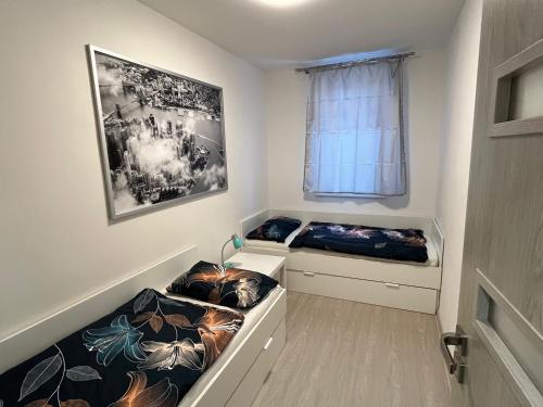 Cette petite chambre comprend 2 lits et une fenêtre. dans l'établissement Apartmán u zámecké zahrady, à Klášterec nad Ohří