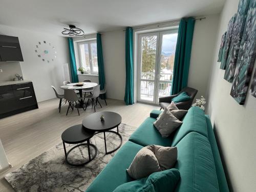 a living room with a green couch and a table at Apartmán u zámecké zahrady in Klášterec nad Ohří