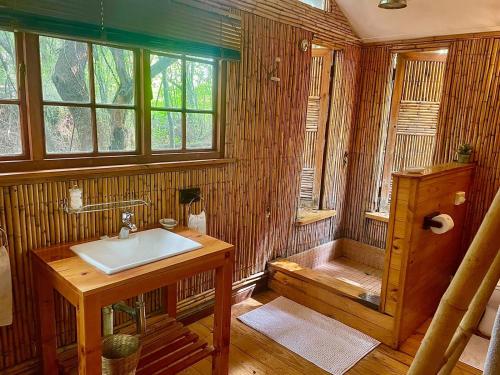 a wooden bathroom with a sink and a tub at Iris Retreat & Island Day Spa in Hartbeespoort