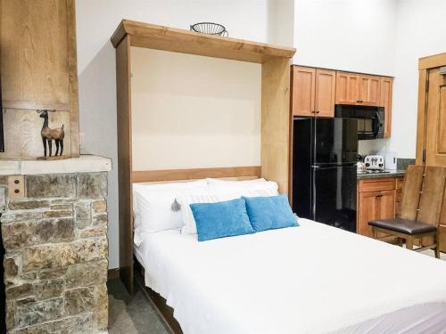 a bedroom with a large white bed with blue pillows at Hyatt Main Street Station Studio in Breckenridge