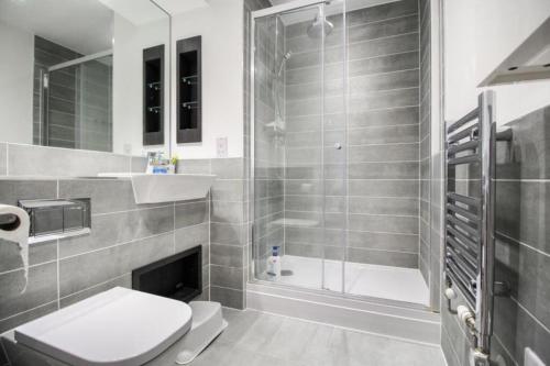 a bathroom with a shower and a toilet and a sink at Stunning two bedroom apartment in London