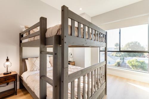 een slaapkamer met een stapelbed en een raam bij Brand New Modern 4 Bedroom House Pickfair Village in Los Angeles