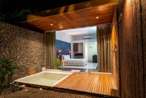 a room with a large glass door leading to a bedroom at Cacaoni Hotel in Puerto Colombia