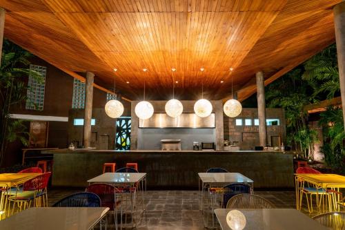 a restaurant with tables and chairs and a bar at Cacaoni Hotel in Puerto Colombia