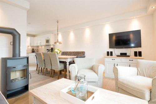 a living room with a fireplace and a dining room at Haus-Seestern in Tinnum