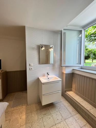 uma casa de banho com um lavatório e uma janela em Villa bernadac em Ornolac-Ussat-les-Bains
