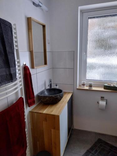 a bathroom with a sink and a window at Ferienwohnung Hoch im Harz, Altenau in Altenau