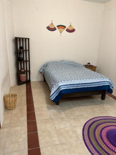 ein Schlafzimmer mit einem Bett auf einem Fliesenboden in der Unterkunft Casa Cruz, Oaxaca in Oaxaca de Juárez