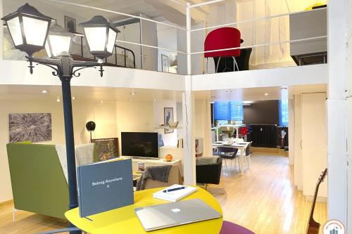 a loft apartment with a desk with a laptop on it at Loft de l'Artiste - Parking - Standing in Rouen
