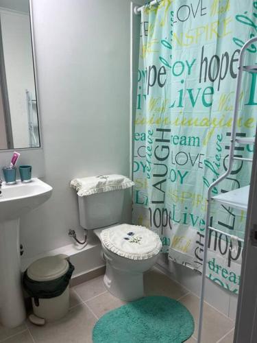 a bathroom with a toilet and a shower curtain at Departamento Peñuelas in Coquimbo