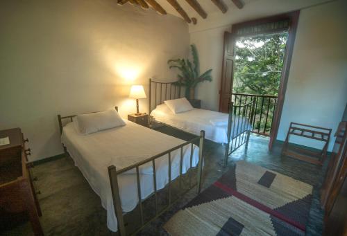 a bedroom with two beds and a balcony with a view at Finca La Argelia in Quimbaya