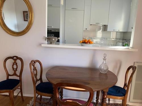 eine Küche mit einem Holztisch mit Stühlen und einem Spiegel in der Unterkunft PARIS 10 ' BASTILLE (CHARENTON LE PONT) in Charenton-le-Pont