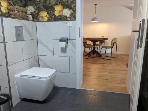 een badkamer met een toilet en een tafel met stoelen bij POLKA in Schwarzenbach an der Saale