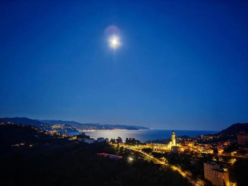 a view of a city at night with the moon at La Mansarda di San Lorenzo in Santa Margherita Ligure