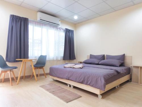 a bedroom with a bed and two chairs and a table at Studio 36 in Bangkok