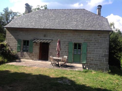 a small brick house with a table and chairs at Gîte de France Les belettes 3 épis - Gîte de France 4 personnes MAE-0304 in Chaumeil