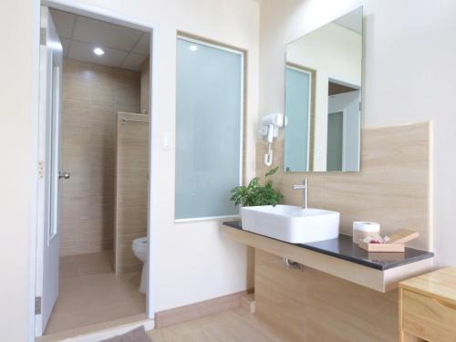 ein Bad mit einem Waschbecken und einem Spiegel in der Unterkunft Studio 36 in Bangkok