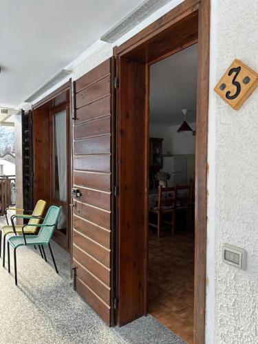 a wooden door to a room with a table and chairs at Maison Moioli - Appartamento 3 in Piamprato