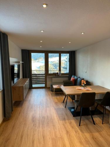 sala de estar con mesa y sofá en Appartements Dobler - s'Zischgn, en Arzl im Pitztal