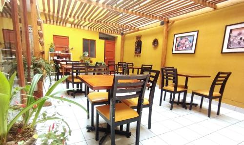 Hotel Yañez Inn في اياكوتشو: مطعم بطاولات وكراسي خشبية في الغرفة