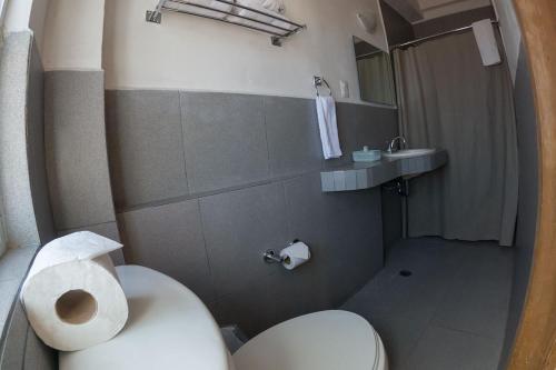uma casa de banho com um WC branco e um lavatório. em Hotel Casablanca em Durango