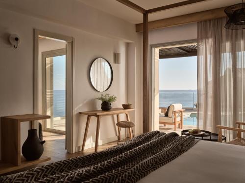 a bedroom with a bed and a view of the ocean at Seaside A Lifestyle Resort - Adults Only in Agia Pelagia