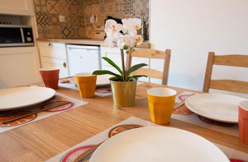 einen Esstisch mit Tellern und Blumen darauf in der Unterkunft Appartement Alegria - Disney - Vallée Village - Paris in Chessy