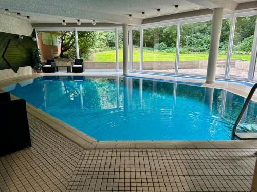 ein großer Pool mit blauem Wasser in einem Gebäude in der Unterkunft Top Apartment Nähe Messe/DUS. in Krefeld