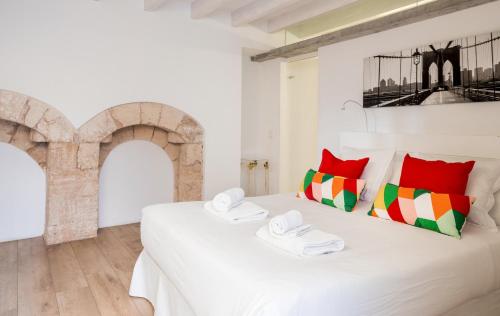 a bedroom with a white bed with red and green pillows at Apartment Santa Cruz Suite TI105 in Palma de Mallorca