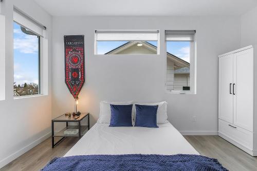 a bedroom with a bed with blue pillows and a window at Tides of Seasmoke Suite in Seattle