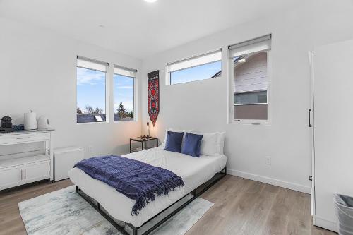 um quarto branco com uma cama e 2 janelas em Tides of Seasmoke Suite em Seattle